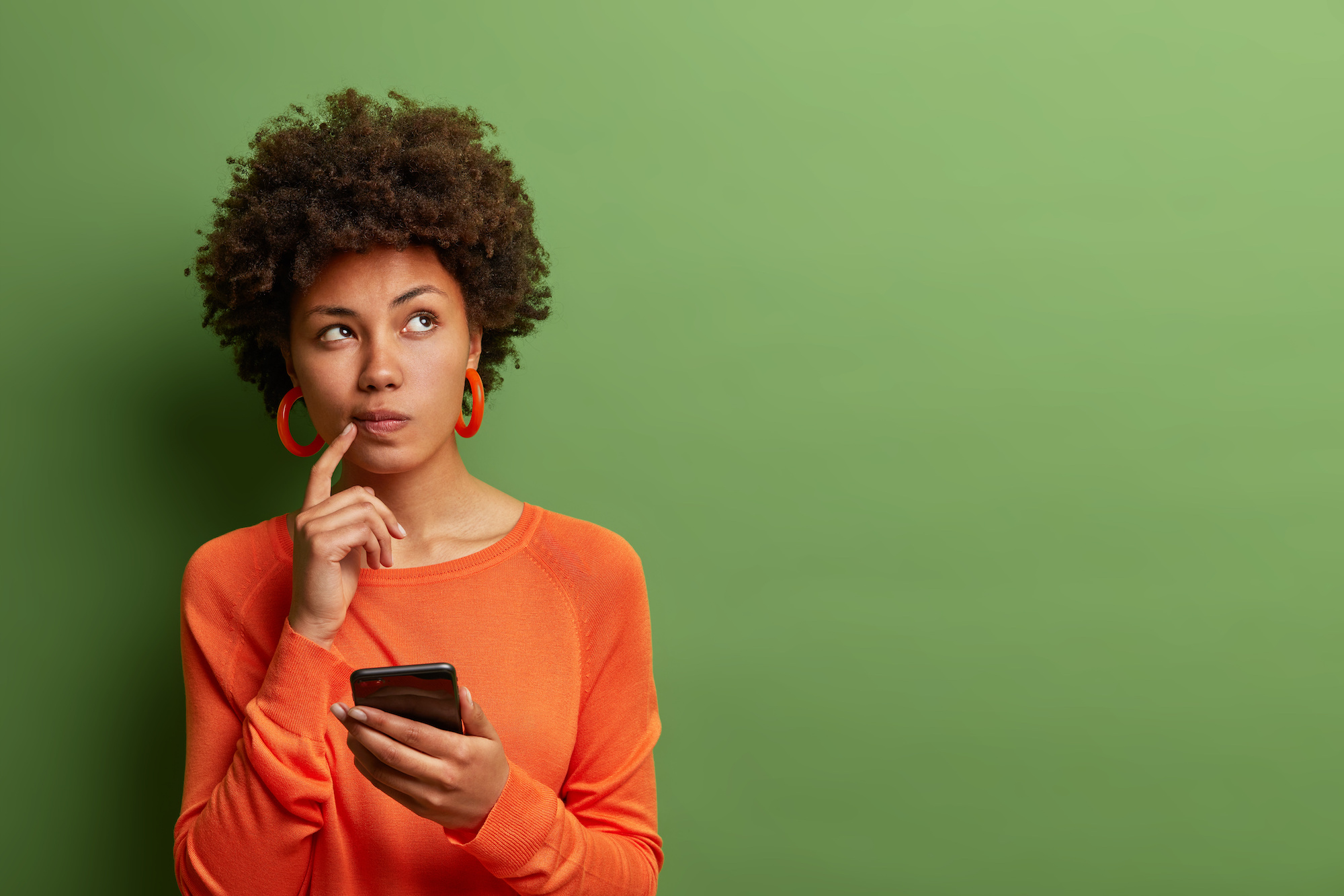 woman holding phone and thinking